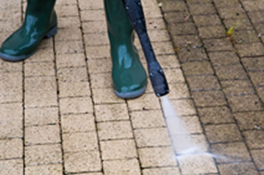 Photo of a pressure washer hose cleaning a wood deck.