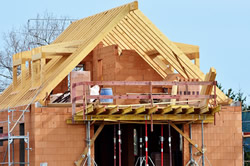 Photo of a roof being built on a house under construction.