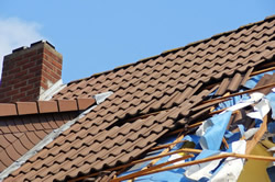 Photo of a roof with broken shingles.